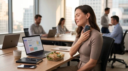 Vagus nerve and appetite concept showing a woman using a vagus nerve stimulation device during a workday with a healthy meal and focus on gut-brain wellness.