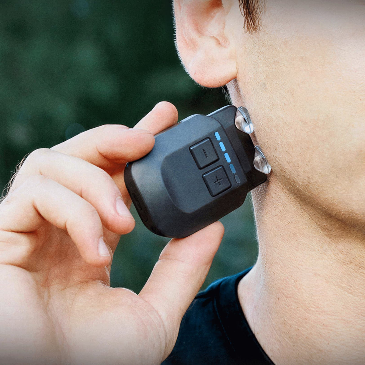A person holding a Hoolest device with gel tips against the side of their neck