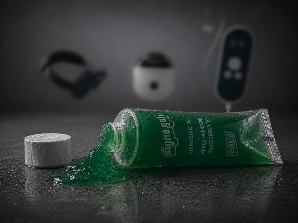 A tube of conductive gel paste beside a used, gel-smeared electrode
