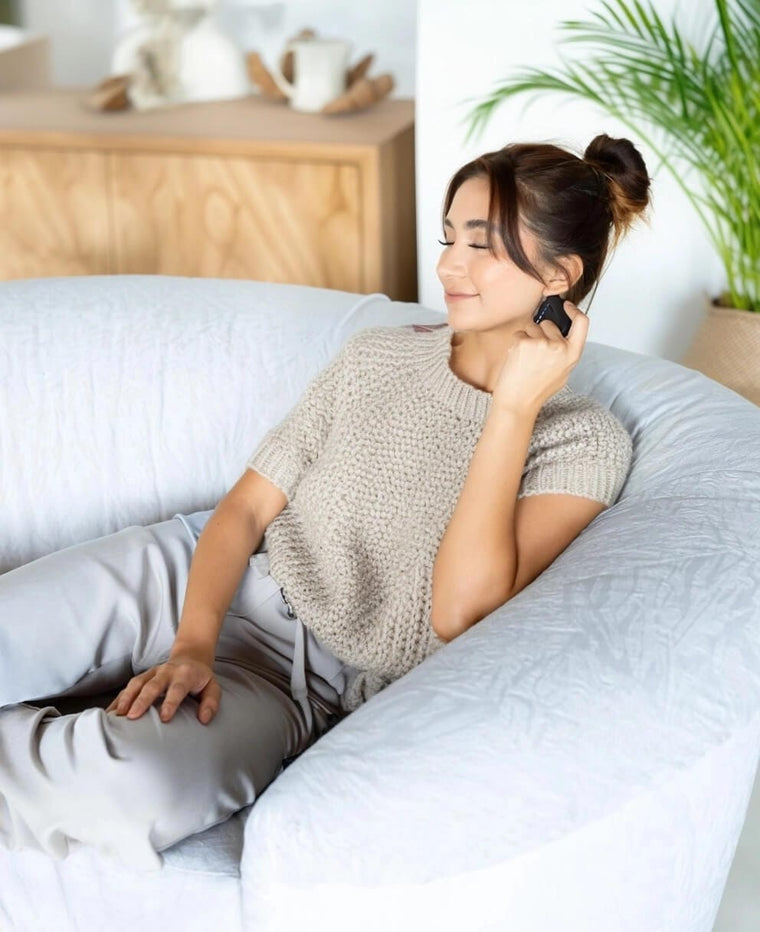 A person holding the device against the neck with their eyes closed